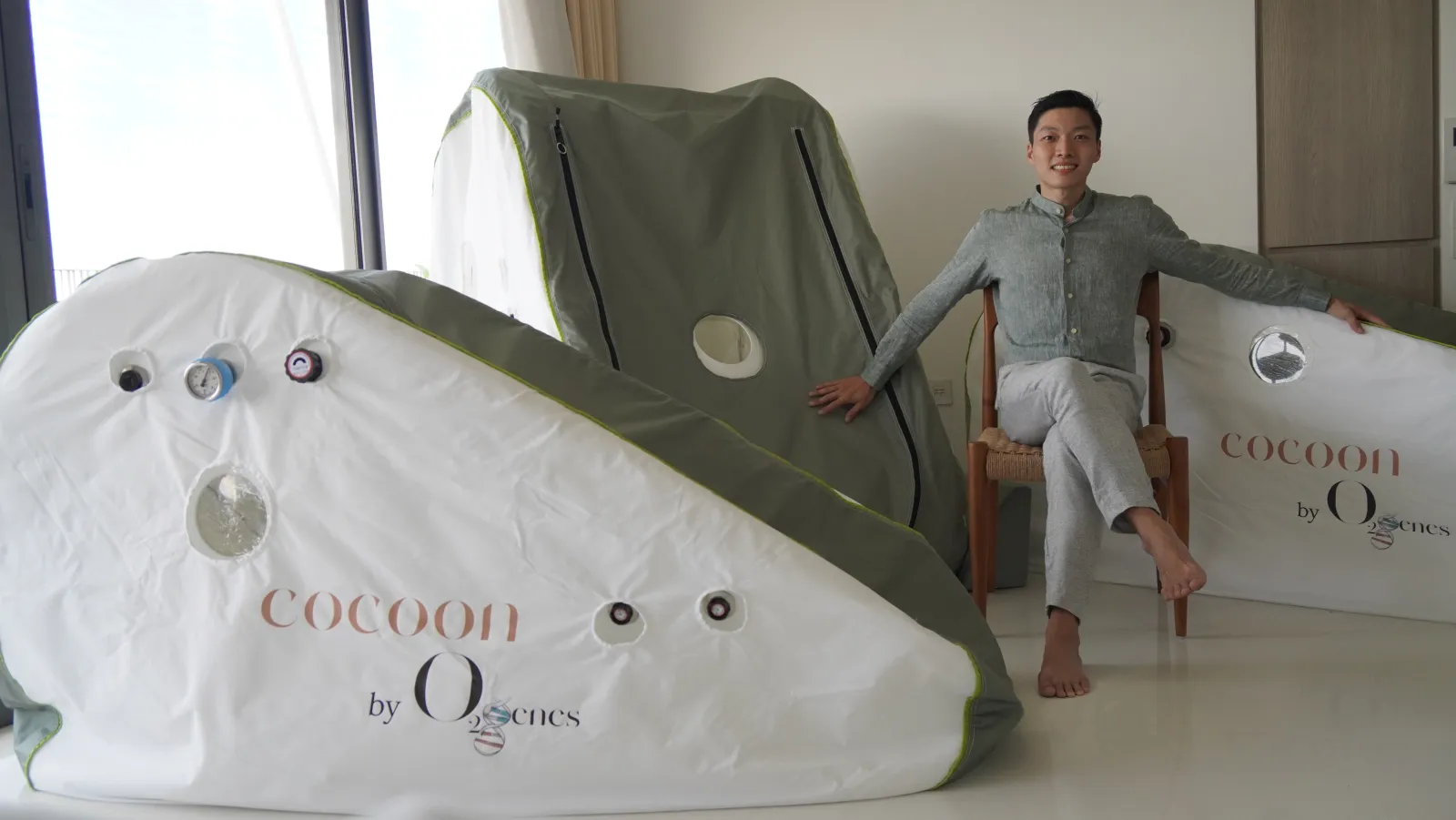 An O2genes founder discussion beside Soft Shell HBOT cocoon® in a home wellness setting
